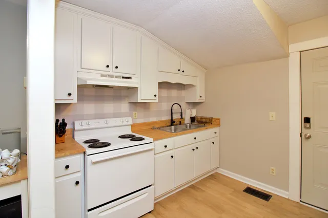 a kitchen with granite countertop white cabinets and white appliances