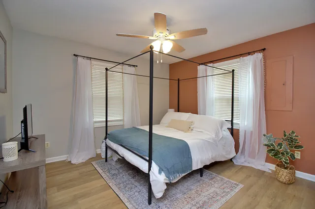 a bedroom with a bed lamp and a potted plant