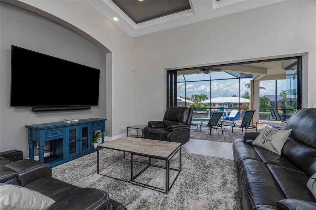 2730 Rio Court Punta Gorda, FL 33950 - Photo 14 of 71 a living room with furniture a flat screen tv and a floor to ceiling window