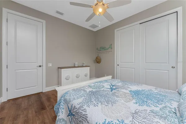 a bedroom with a bed and a flat tv screen on dresser