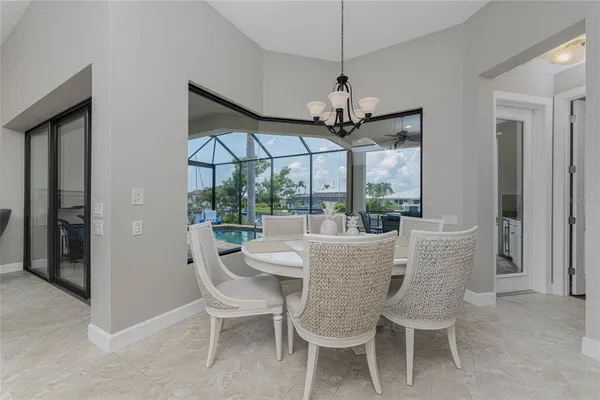 a kitchen with stainless steel appliances granite countertop a table chairs sink and cabinets