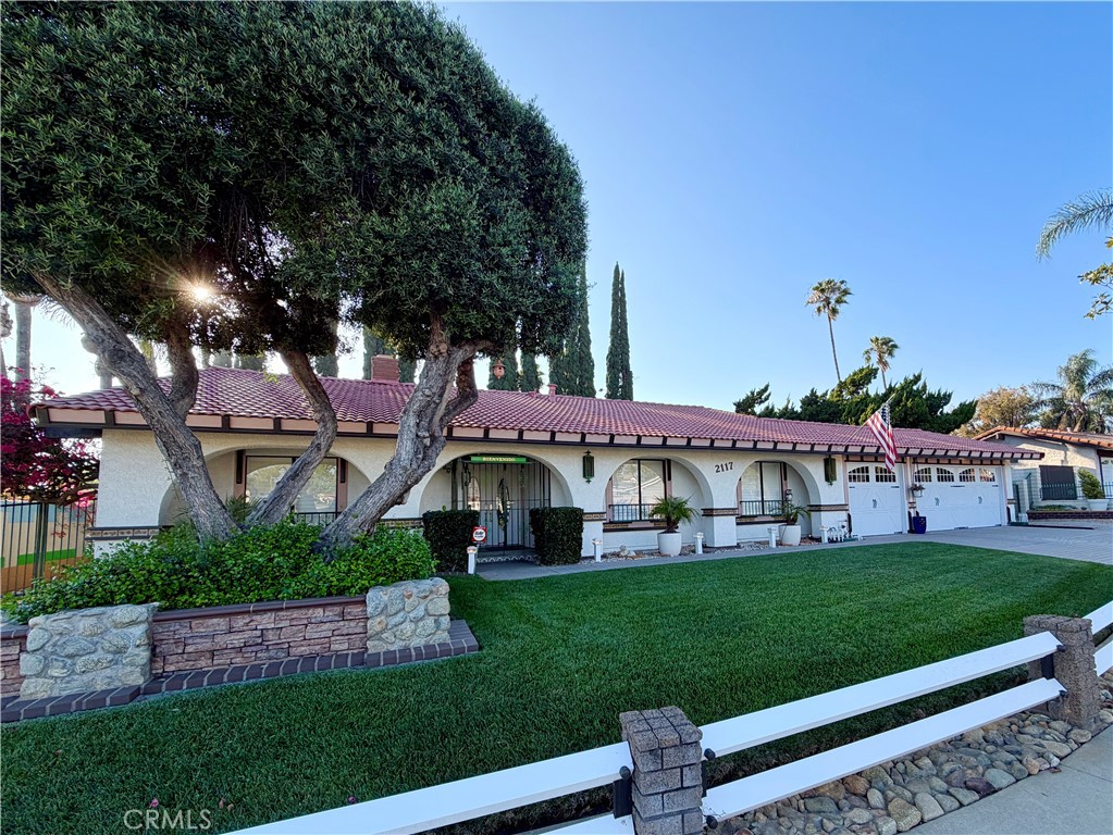 a front view of a house with a yard and green space