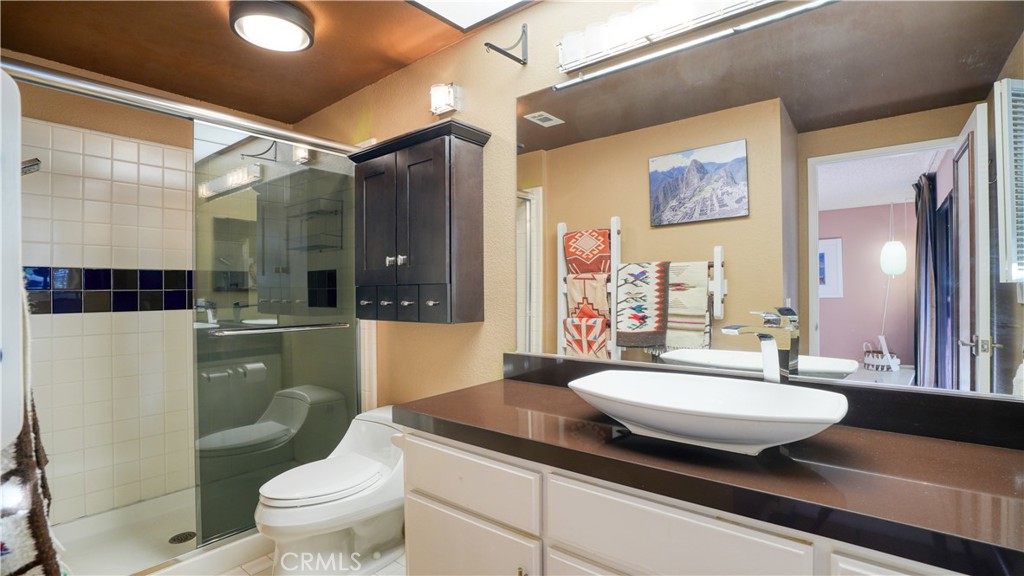 2117 Capuchin Way Claremont, CA 91711 - Photo 21 of 36 a bathroom with a granite countertop sink toilet a mirror and shower