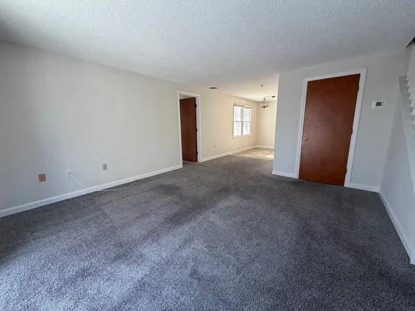 a view of an empty room with closet and window