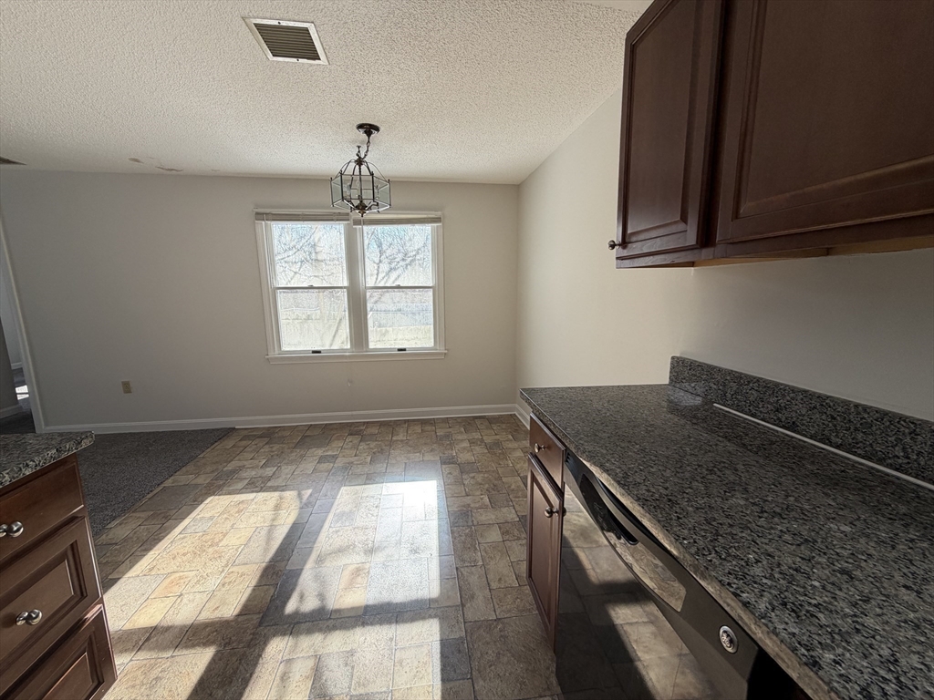 213 Victoria Heights Road, Unit 213 Boston, MA 02136 - Photo 6 of 18 a kitchen with granite countertop a sink stove and cabinets