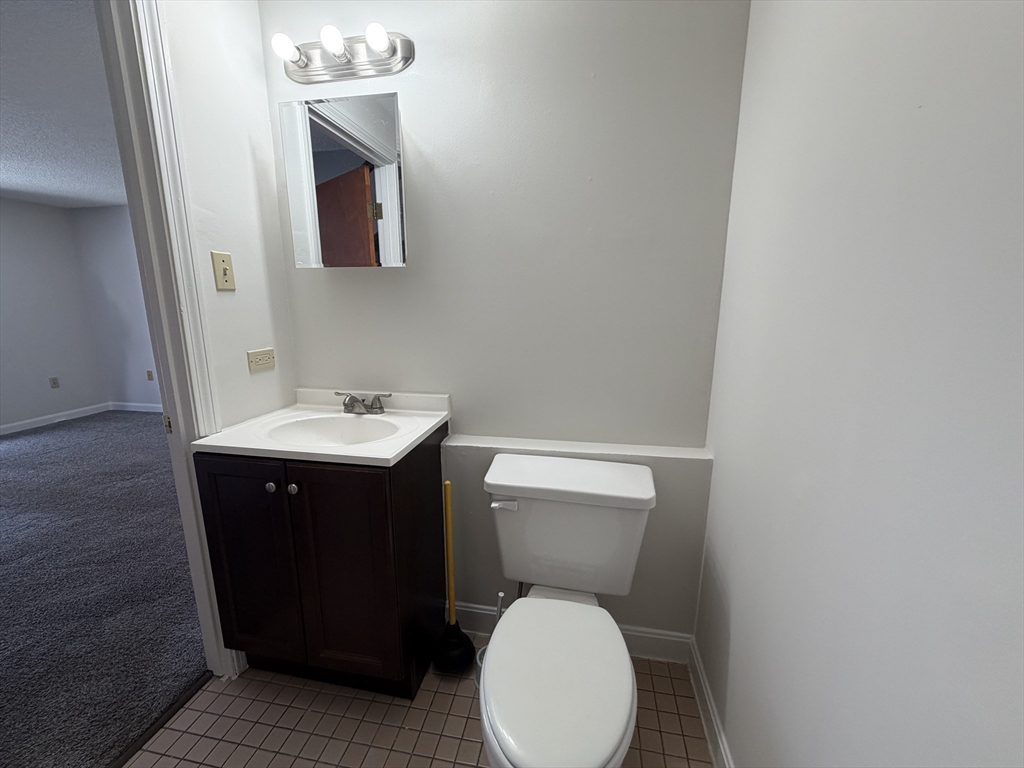 213 Victoria Heights Road, Unit 213 Boston, MA 02136 - Photo 10 of 18 a bathroom with a toilet sink and mirror