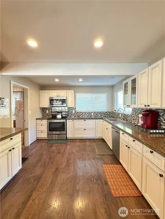 a kitchen with white cabinets and white appliances