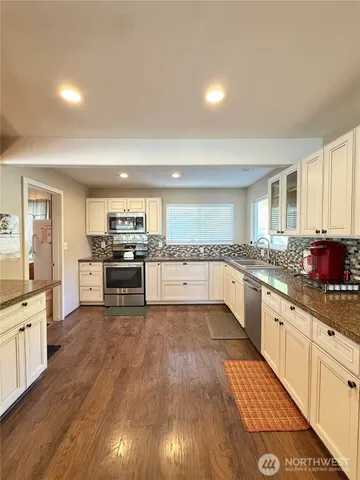 a kitchen with white cabinets and white appliances