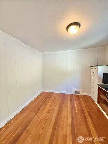 a view of room with wooden floor and furniture