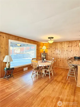 a kitchen with stainless steel appliances granite countertop a stove a sink and white cabinets with wooden floor