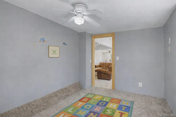 a view of an empty room and a ceiling fan