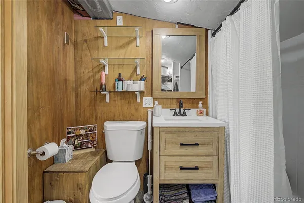 a bathroom with a granite countertop toilet sink and mirror