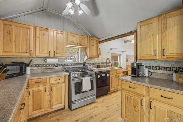 a kitchen with stainless steel appliances granite countertop a stove sink and cabinets