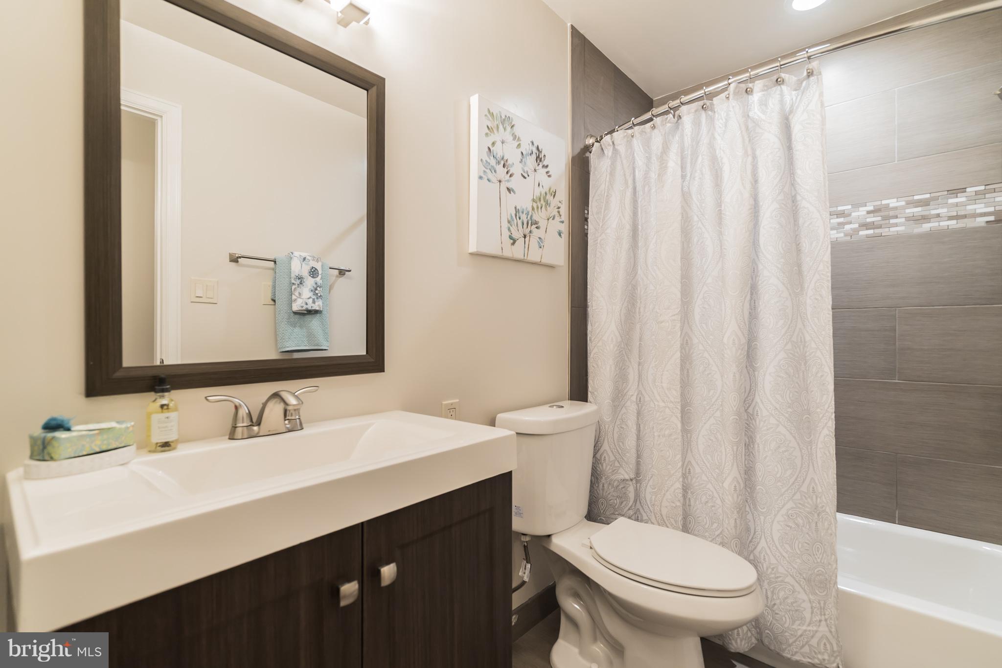 9541 Warfield Road Gaithersburg, MD 20882 - Photo 17 of 29 Main level hall bath w custom tile work.