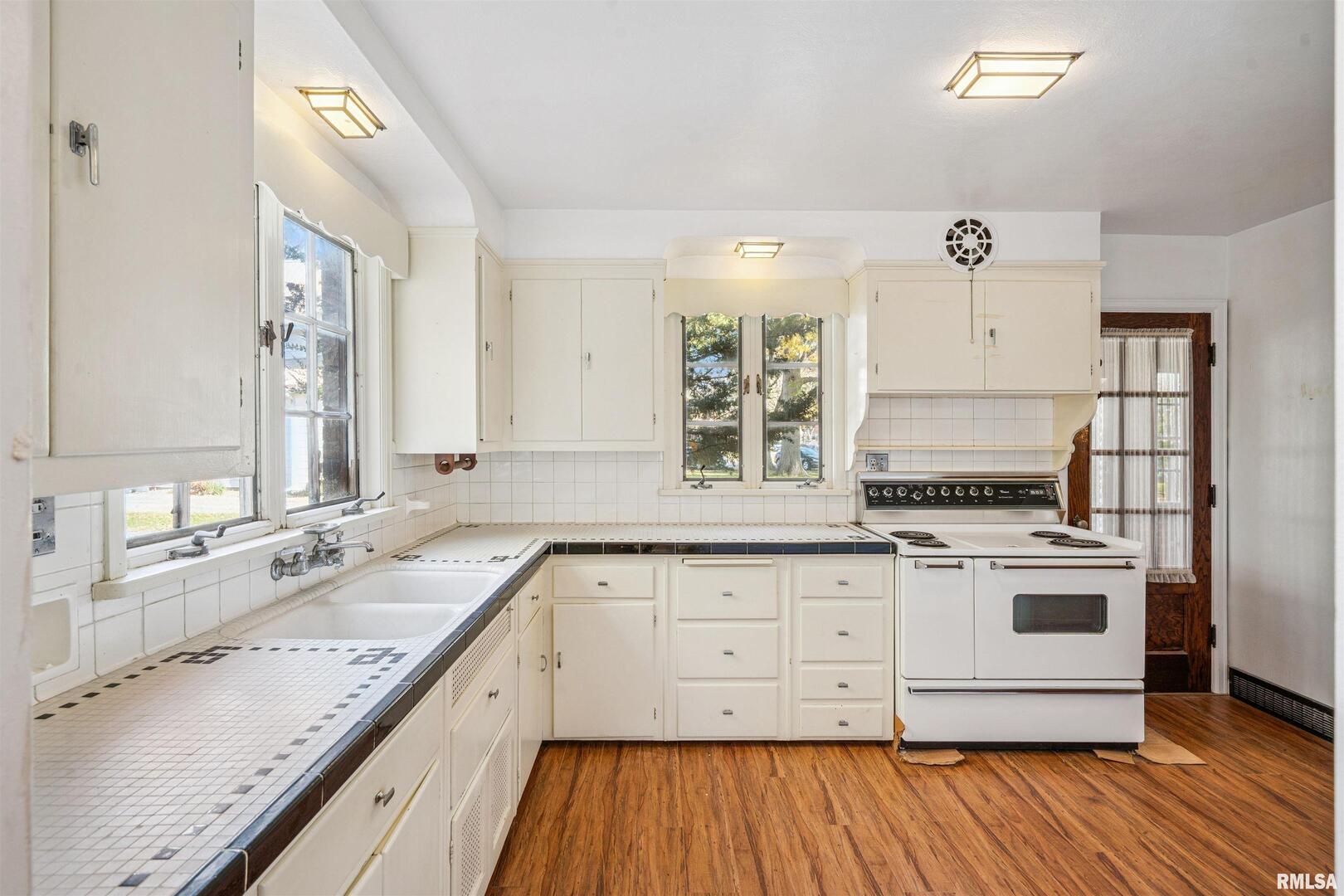 314 West 3rd Street Prophetstown, IL 61277 - Photo 5 of 29 a kitchen with a stove a sink and wooden floor