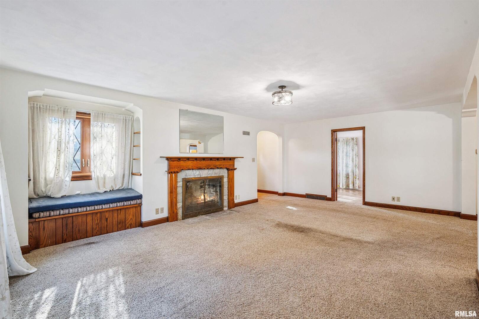 314 West 3rd Street Prophetstown, IL 61277 - Photo 8 of 29 an empty room with fireplace cabinet and windows