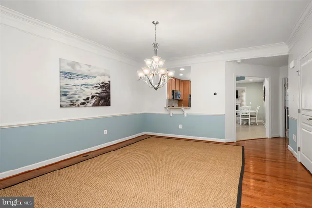 a kitchen with stainless steel appliances granite countertop a stove top oven a refrigerator a sink and chairs