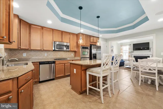 a kitchen with stainless steel appliances granite countertop a sink a stove top oven a counter space and cabinets