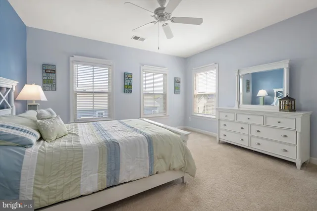a spacious bedroom with a bed and a dresser