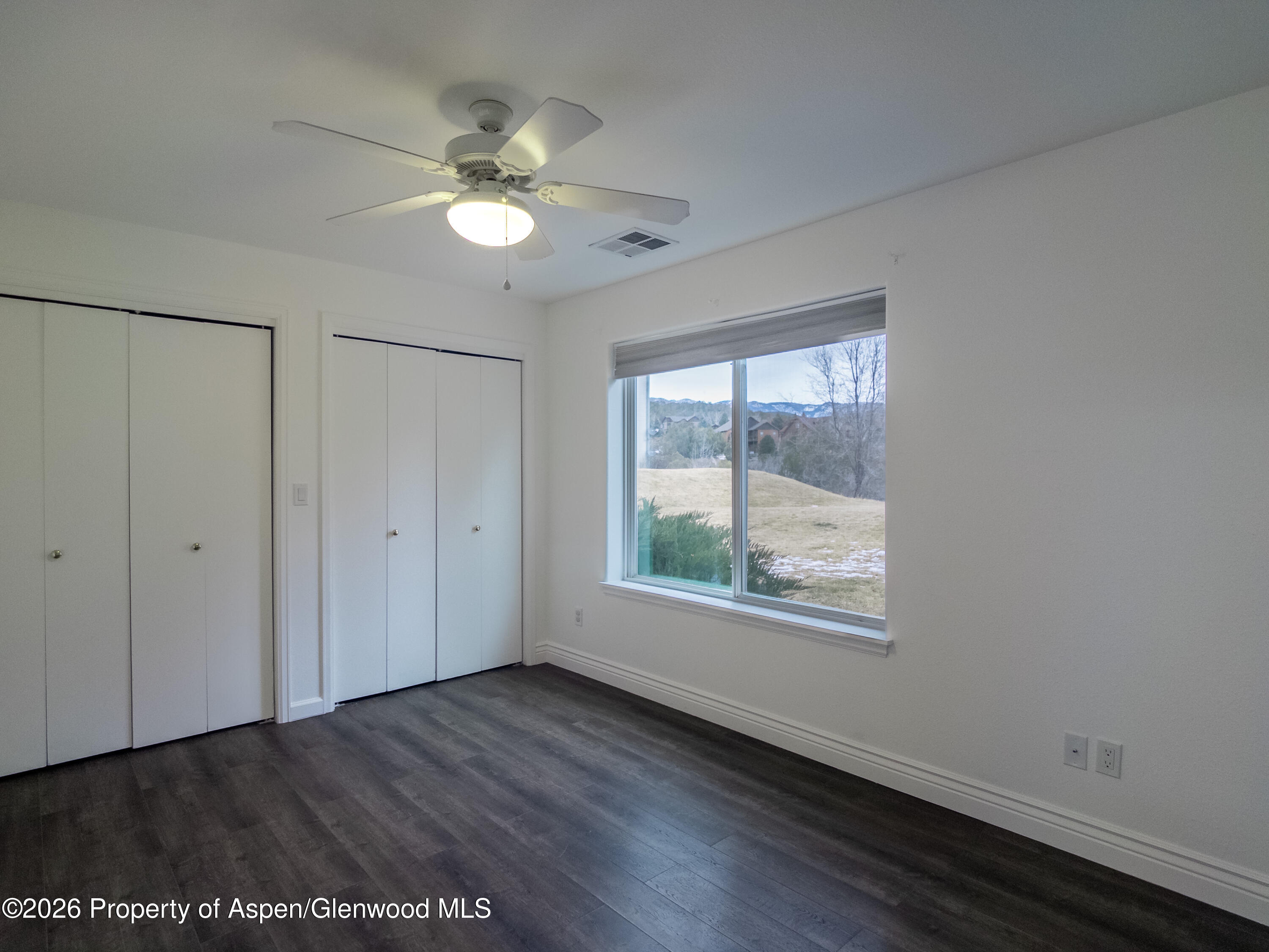 792 Castle Valley Boulevard, Unit B New Castle, CO 81647 - Photo 9 of 25 a view of an empty room with a window and wooden floor