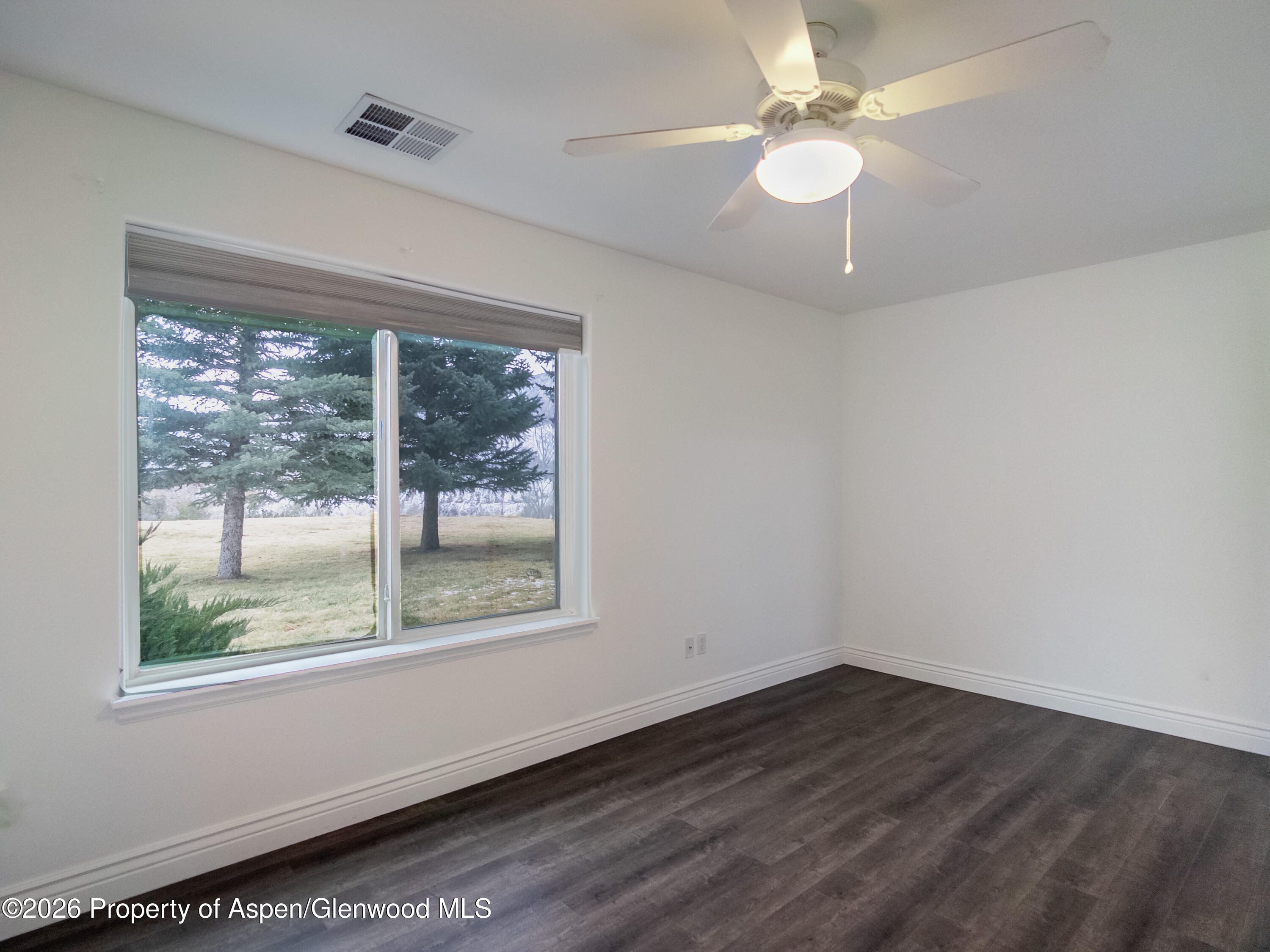 792 Castle Valley Boulevard, Unit B New Castle, CO 81647 - Photo 10 of 25 an empty room with wooden floor and windows