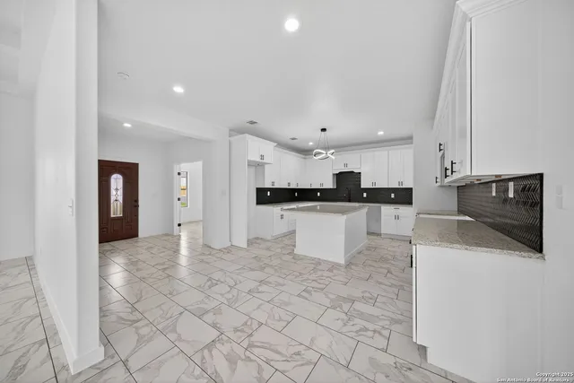 a view of kitchen with stainless steel appliances refrigerator sink and cabinets