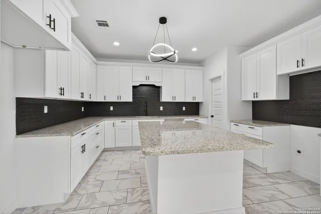 a kitchen with stainless steel appliances granite countertop a sink a stove and cabinets