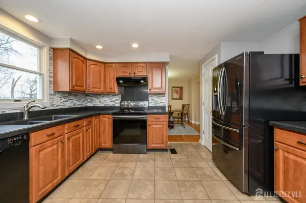 a kitchen with stainless steel appliances granite countertop a refrigerator and a sink