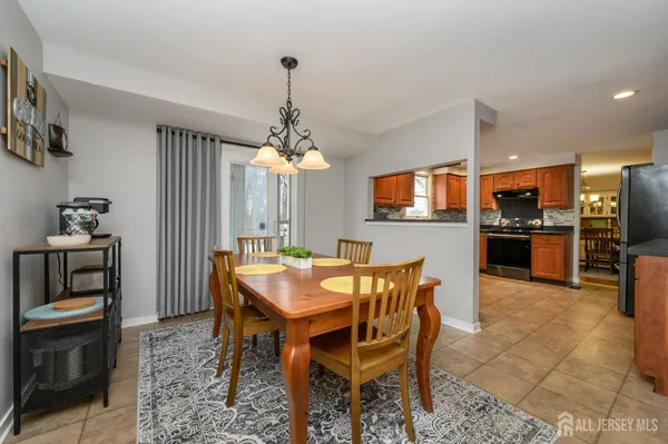 a dining room with furniture a chandelier and kitchen view
