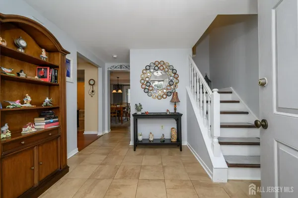 a view of a hallway to room with wooden floor and furniture