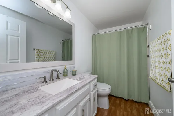 a bathroom with a granite countertop sink toilet and shower