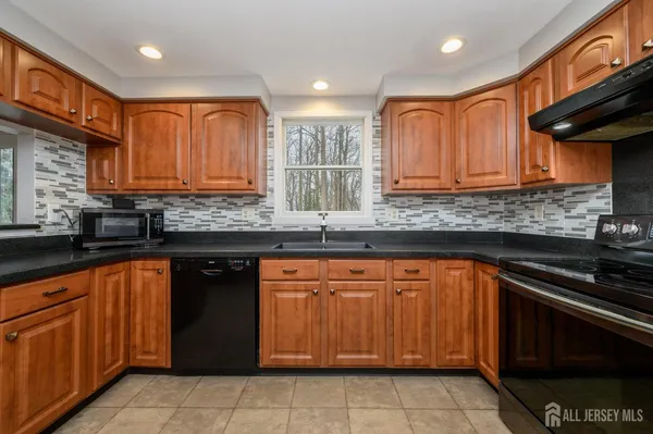 a kitchen with granite countertop cabinets sink and stainless steel appliances