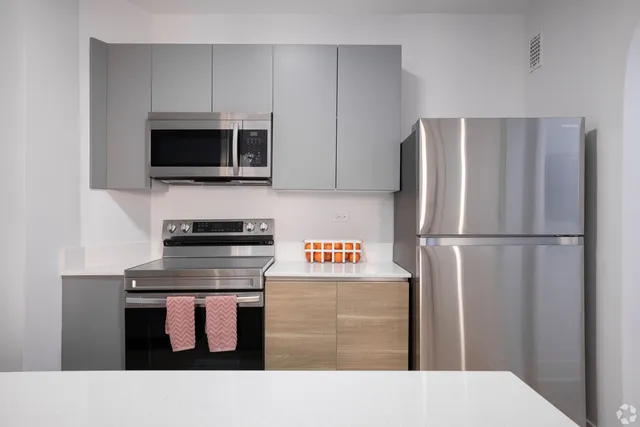 a kitchen with stainless steel appliances kitchen island granite countertop a refrigerator a stove top oven a sink and dishwasher