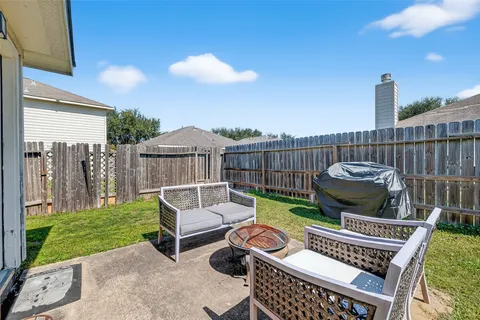 a view of a chair and tables in the back yard of the house