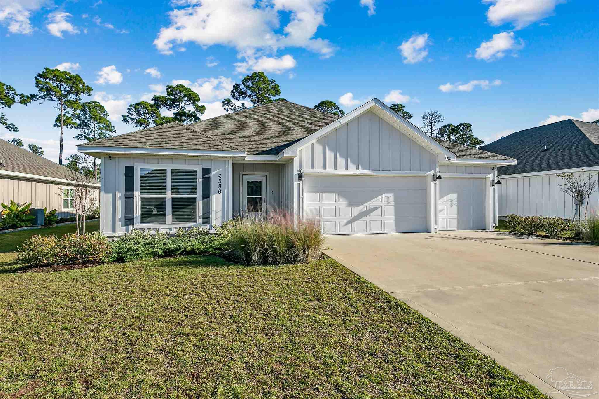 6580 Forest Bay Avenue Gulf Breeze, FL 32563 - Photo 1 of 29 a front view of a house with a garden