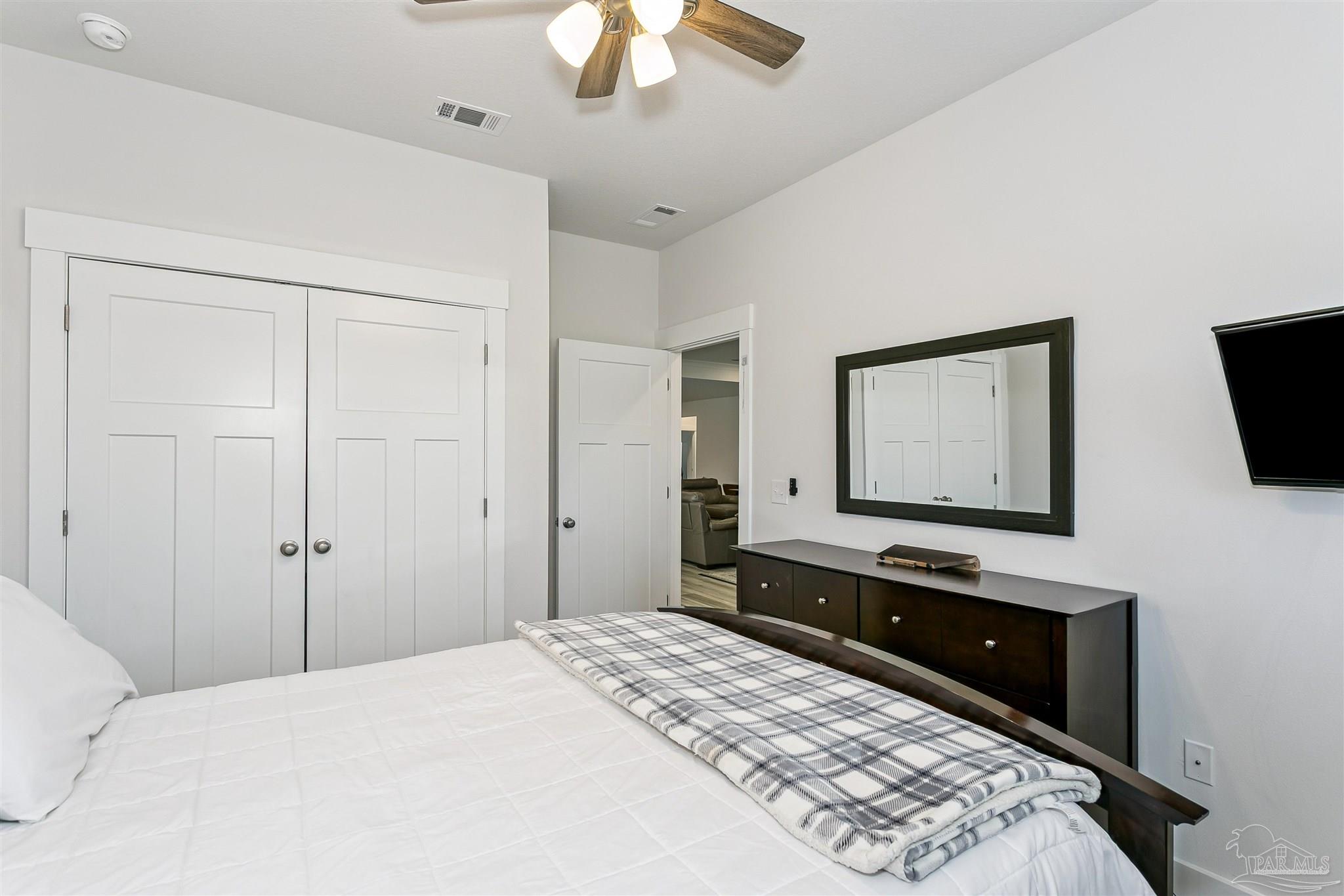 6580 Forest Bay Avenue Gulf Breeze, FL 32563 - Photo 19 of 29 a bedroom with a bed and a flat tv screen on dresser