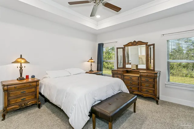 a bedroom with a bed and large windows