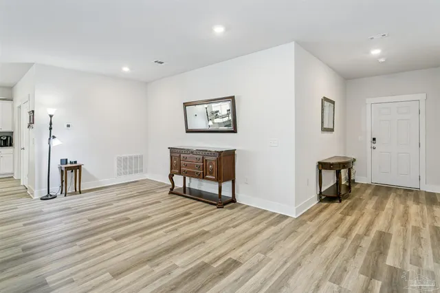 a view of a livingroom with wooden floor and furniture