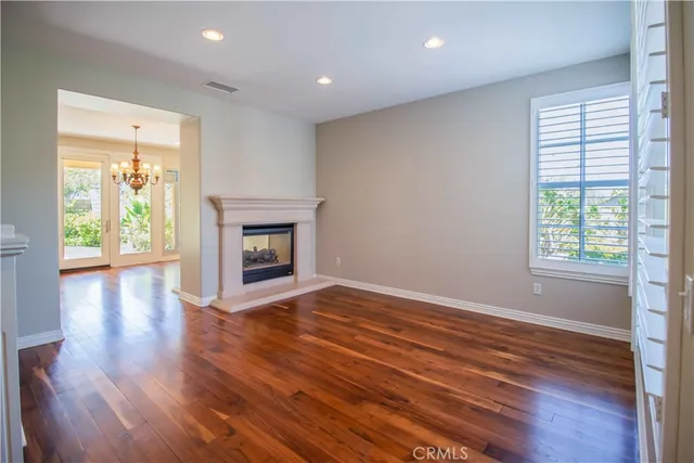 a view of a room with wooden floor chandelier and windows