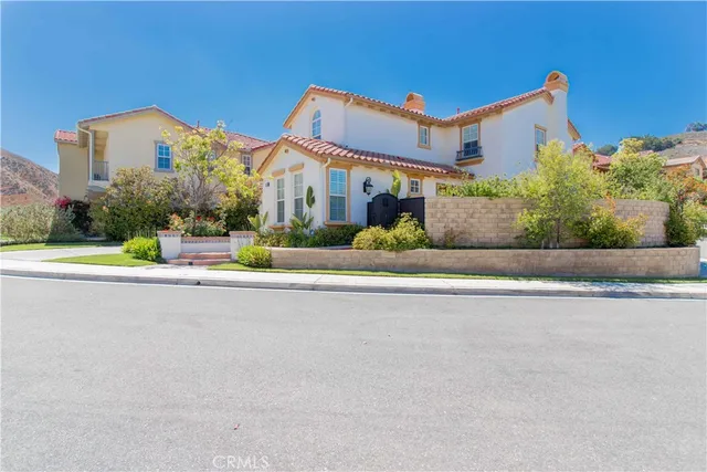 a front view of a house with a yard and large trees