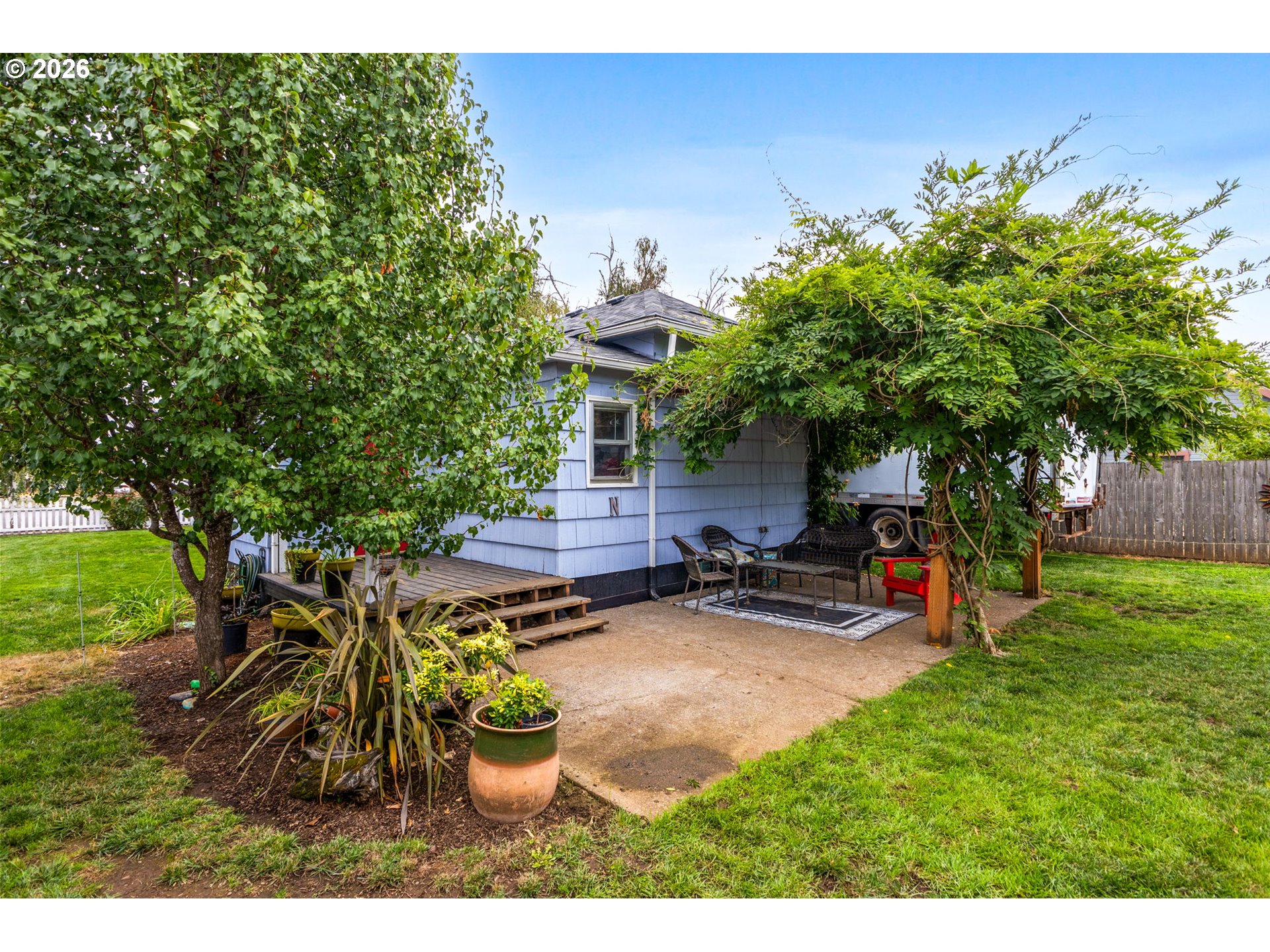 1071 Southwest Church Street Dallas, OR 97338 - Photo 22 of 27 a view of a backyard with couches and table and chairs under an umbrella