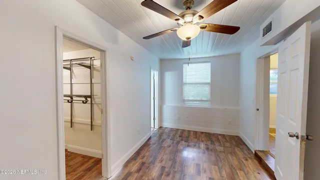 a view of room with window ceiling fan and hardwood floor