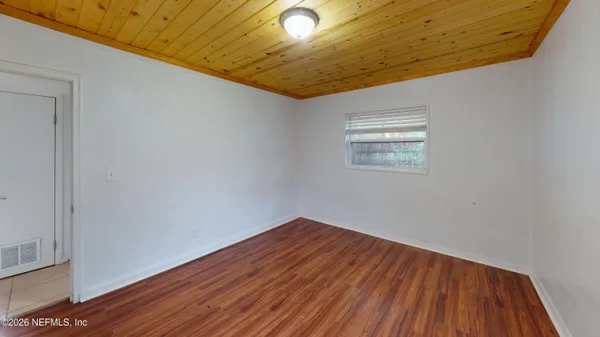 a view of empty room with wooden floor