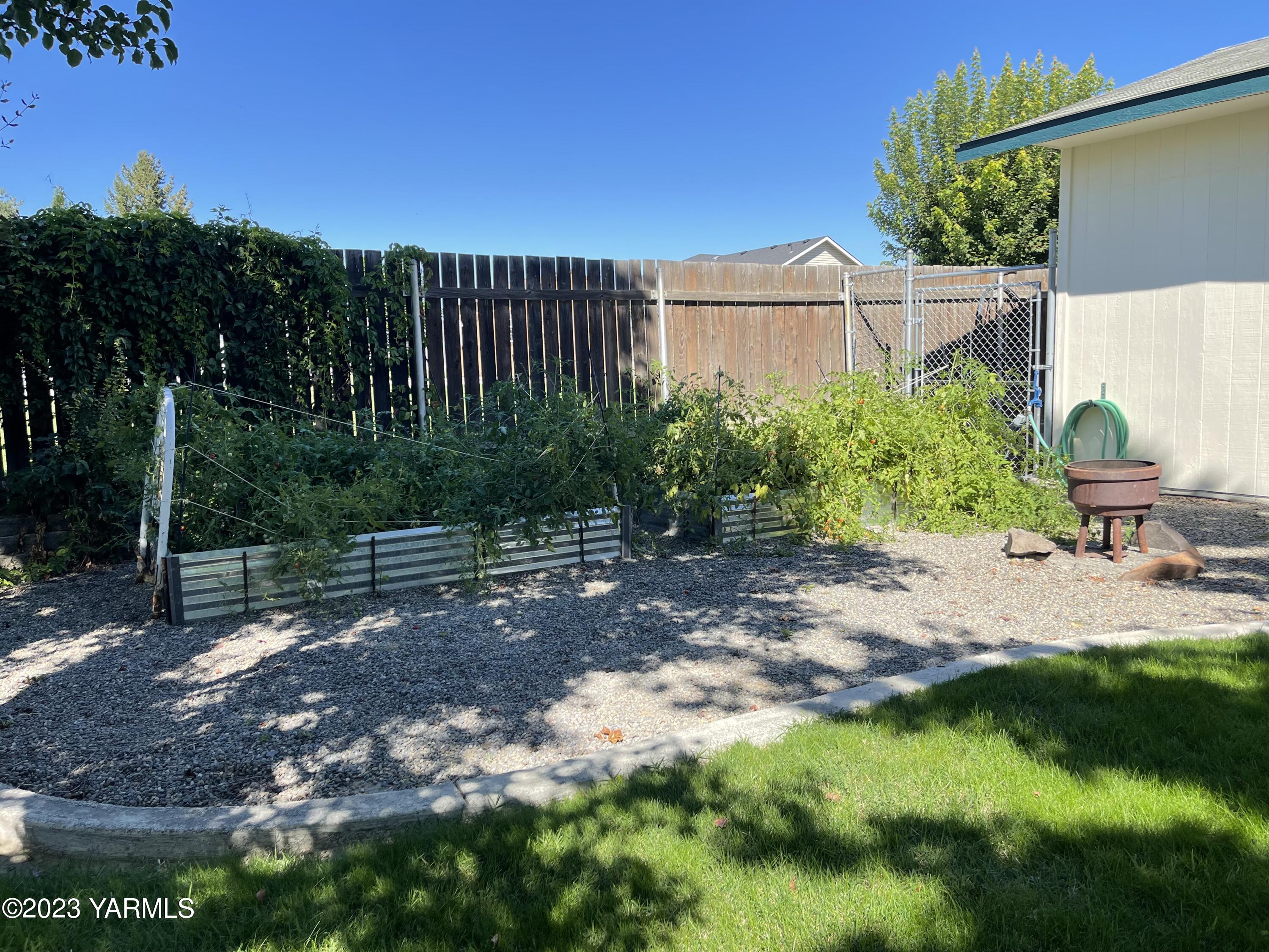 707 Larson Street Grandview, WA 98930 - Photo 14 of 16 a view of a backyard with plants and a patio