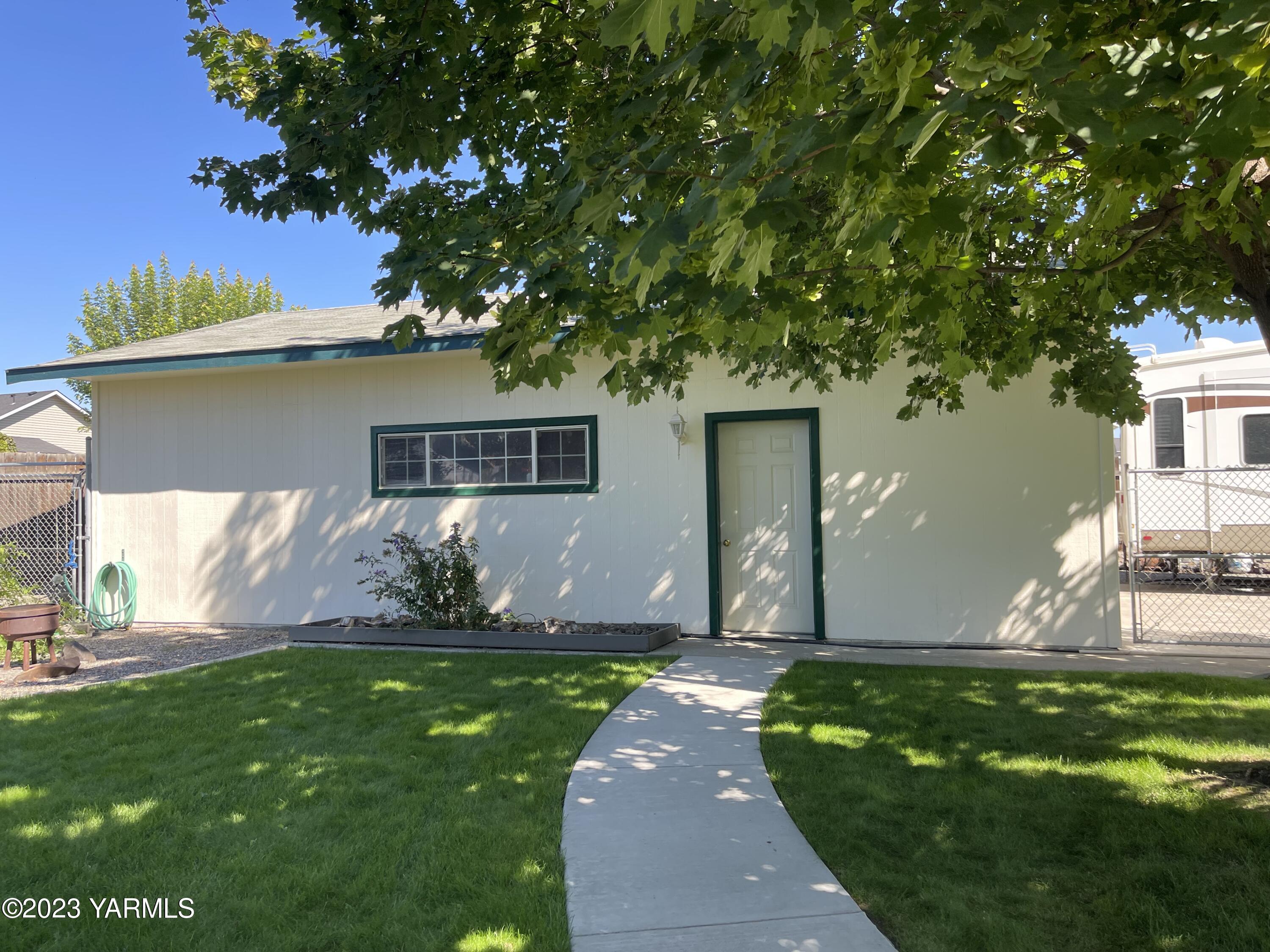 707 Larson Street Grandview, WA 98930 - Photo 15 of 16 a front view of a house with a garden and yard