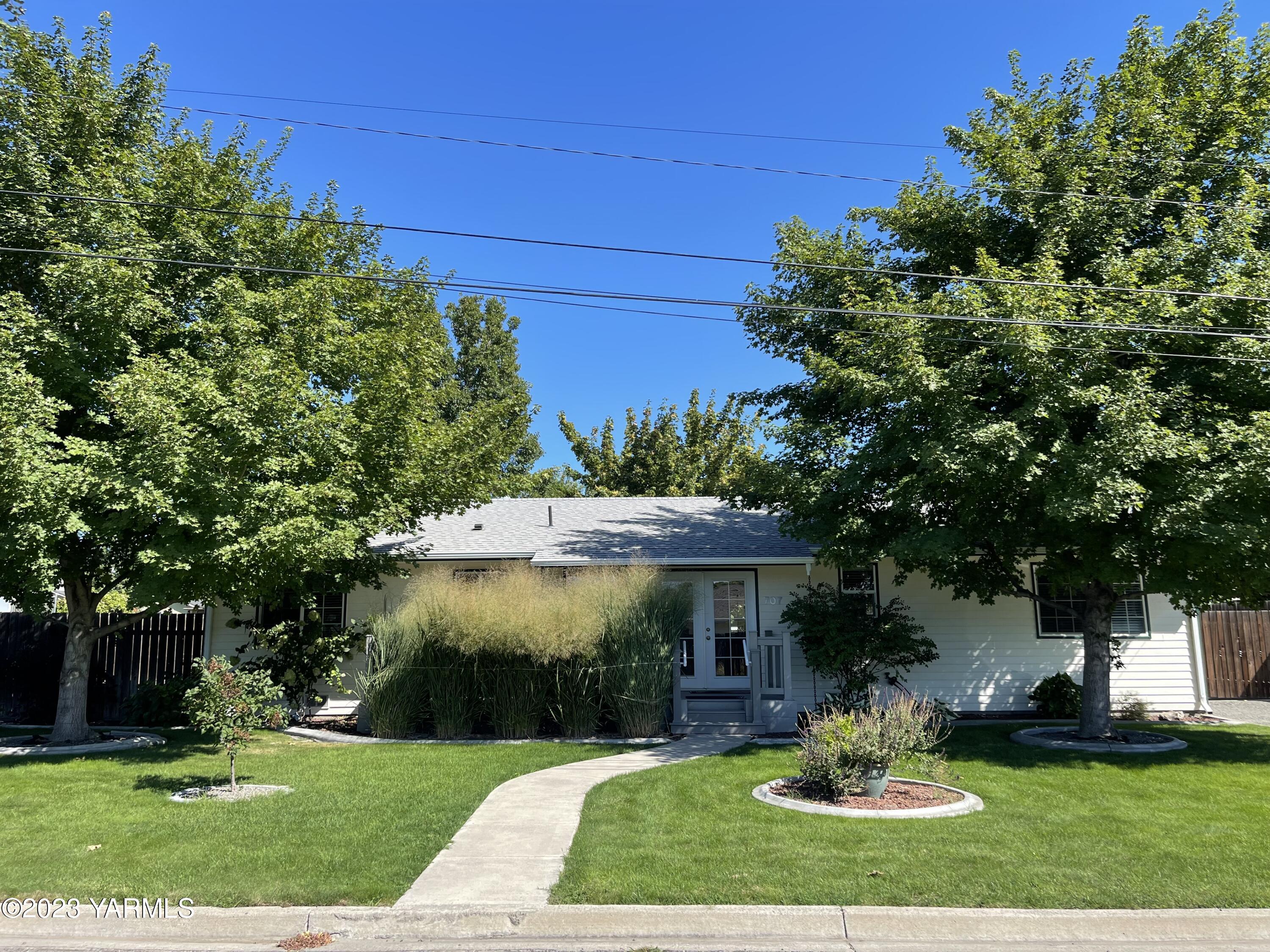707 Larson Street Grandview, WA 98930 - Photo 16 of 16 a front view of a house with a yard potted plants and a large tree