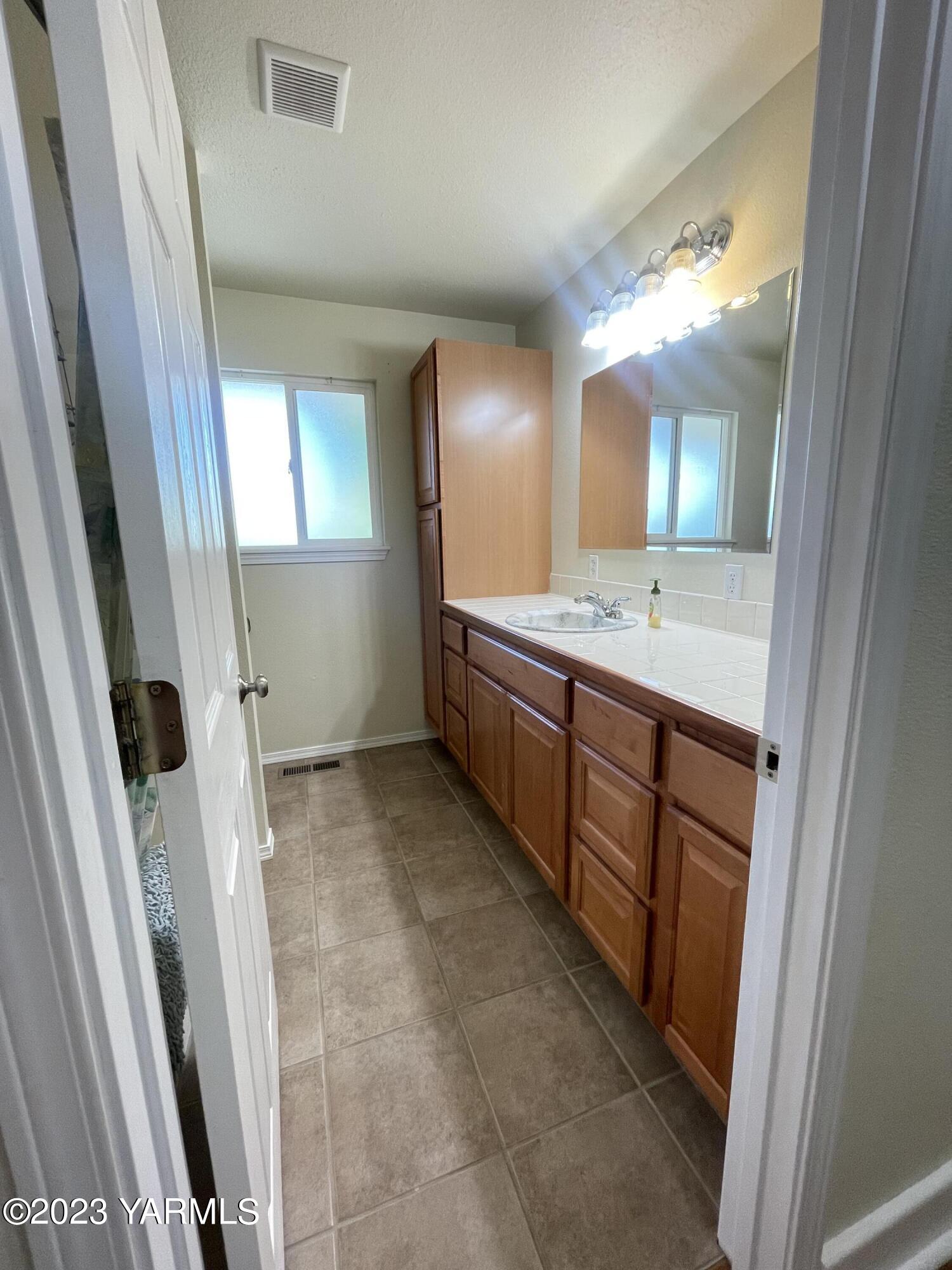 707 Larson Street Grandview, WA 98930 - Photo 5 of 16 a bathroom with a double vanity sink and mirror
