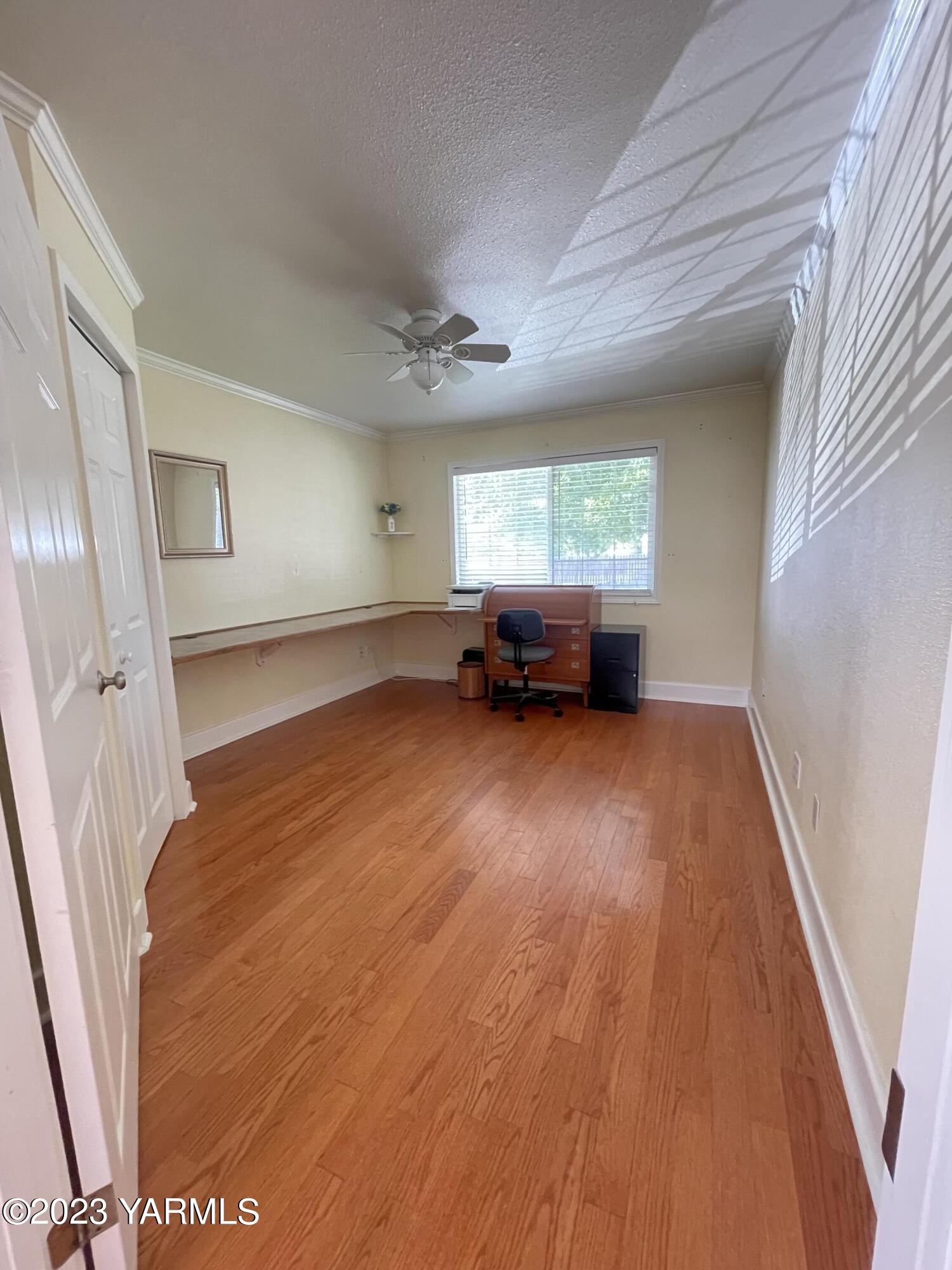 707 Larson Street Grandview, WA 98930 - Photo 6 of 16 a view of empty room with wooden floor and fan