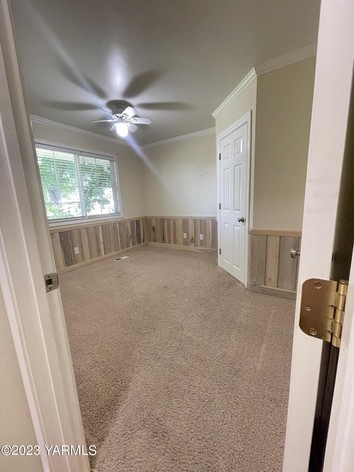707 Larson Street Grandview, WA 98930 - Photo 7 of 16 a view of an empty room with wooden floor and a window