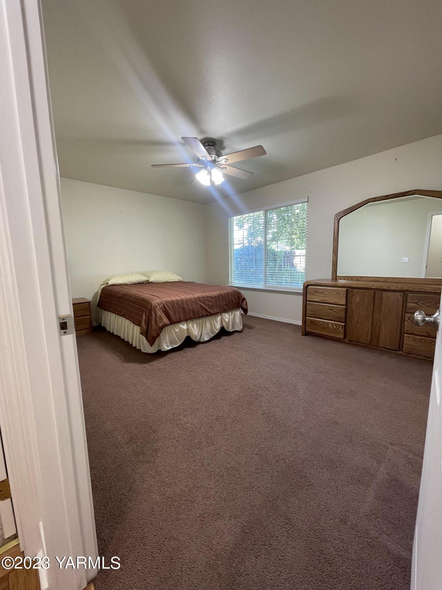 707 Larson Street Grandview, WA 98930 - Photo 8 of 16 a spacious bedroom with a bed and a dresser